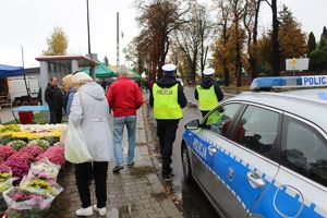 Radiowóz i patrol policyjny przy cmentarzu.