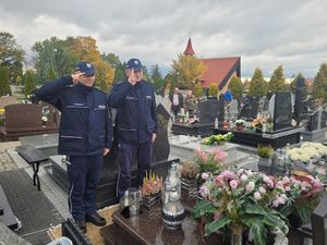 I Zastępca Komendanta Powiatowego Policji w Wieluniu i Naczelnik Prewencji oddają hołd na cmentarzu przed pomnikiem zmarłego policjanta.