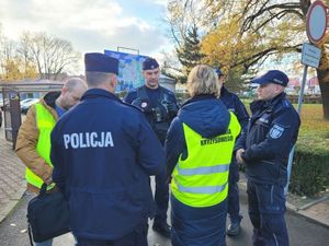 Policjanci uczestniczący w ćwiczeniach rozmawiają z przedstawicielem zarządzania kryzysowego.