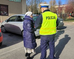 Policjant wręcza kobiecie serduszko zapachowe.