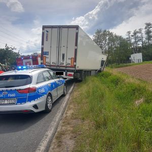 Radiowóz , wóz strażacki i samochód ciężarowy w miejscu wypadku drogowego.