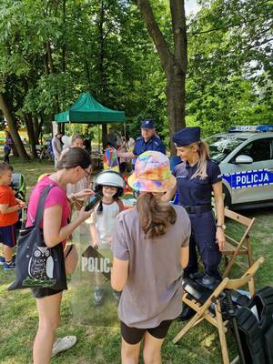 zdjęcie przedstawiające policjanta oraz dzieci i ich rodziców na pikniku z okazji Dnia Dziecka