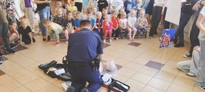 zdjęcie przedstawiające policjanta edukującego dzieci w zakresie pierwszej pomocy