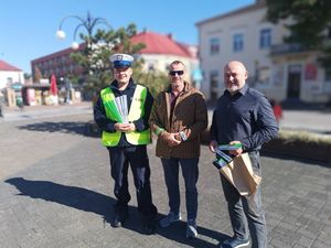 zdjęcie przedstawia policjanta, pracownika GOKO oraz osobę, która otrzymała odblask