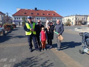 zdjęcie przedstawia policjanta, pracownika GOKO oraz osoby, które otrzymały odblaski