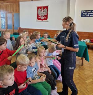 zdjęcie przedstawiające policjantkę wręczającą elementy odblaskowe