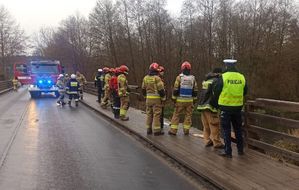 Miejsce zdarzenia na moście , policjanci, strażacy zabezpieczają miejsce zdarzenia.