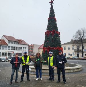 Policjanci wręczają przechodniom długopisy i elementy odblaskowe.