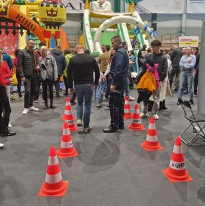 Policjant stoi przy torze przeszkód, mężczyzna pokonuje tor w alkogoglach.