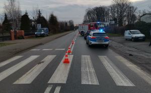 Droga, przejście dla pieszych gdzie doszło do wypadku. Na drodze stoją radiowóz, auto  biorące udział w zdarzeniu i wóz strażacki.