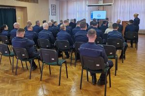 Sala odpraw wieluńskiej komendy na krzesłach siedzą policjanci i zaproszeni goście.