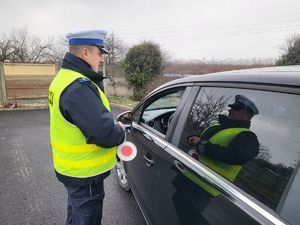 Policjant wręcza kierowcy serduszko zapachowe Zwolnij. Jak kocha to poczeka!