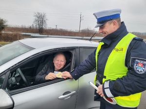 Policjant wręcza kierowcy serduszko zapachoweZwolnij. Jak kocha to poczeka!