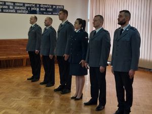 W auli komendy w szeregu stoją policjanci. Odchodzący na emeryturę Komendant Komisariatu Policji w Białej, oraz policjanci awansowani i wyróżnieni.