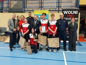 Uczestnicy turnieju pozują z pucharem, medalami wraz z gośćmi do wspólnego zdjęcia.