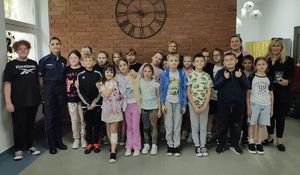 Dzieci ze Szkoły Podstawowej w Kurowie, które uczestniczyły a konkursie pozują w szkole do zdjęcia z nauczycielką i policjantkami.
