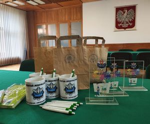 Statuetki za zajęcie trzech pierwszych miejsc, kubki, długopisy i notesy przygotowane dla uczniów.