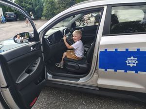 Chłopiec siedzi w radiowozie.