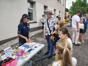 Policjantka rozmawia z uczestnikami pikniku.