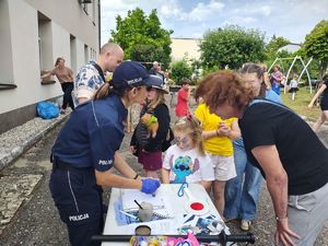 Policjantka robi pamiątkowe odciski linii papilarnych.