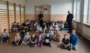 Policjanci prowadzą pogadankę w szkole z uczniami.