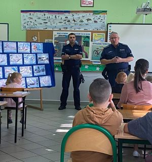 Policjanci w szkole z uczniami prowadzą pogadankę.