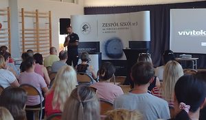 Policjant w sali gimnastycznej prowadzi pogadankę z rodzicami.