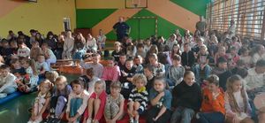 Dzielnicowy w sali w szkole wspólnie z nauczycielami i dziećmi.