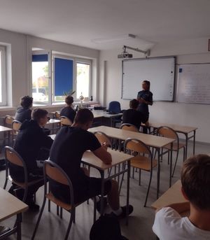 Policjantka prowadzi prelekcje z uczniami  w  klasie.