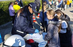 Policjantka wykonuje pamiątkowe odbitki linii papilarnych.
