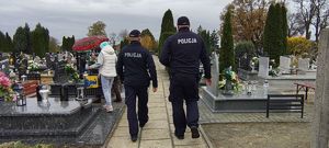 Dzielnicowi idą przez cmentarz w Wieluniu.