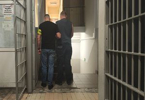 Policjant prowadzi zatrzymanego