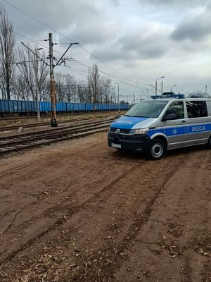 Oznakowany radiowóz przy torach kolejowych