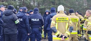 Policjanci i strażacy w miejscu koncentracji sił w miejscu gdzie będą prowadzone poszukiwania zaginionego.