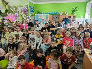 Dzielnicowi stoi w klasie pośród dzieci.