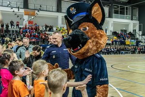 Maskotka policyjna komisarz Alex podchodzi do dzieci.