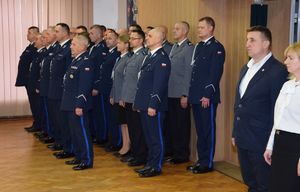 W auli Komendy Powiatowej Policji w Wieluniu podczas uroczystej zbiórki z okazji zdania i powierzenie obowiązków na stanowisku Komendanta Powiatowego Policji w Wieluniu policjanci w umundurowaniu wyjściowym stoją w szyku.