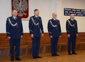 A auli wieluńskiej jednostki Policji stoi I Zastępca Komendanta Wojewódzkiego Policji w Łodzi, po jego prawej stronie młodszy inspektor Grzegorz Kurek, z lewej strony podinspektor Tomasz Lubiński oraz I Zastępca Komendanta Powiatowego Policji w Wieluniu.