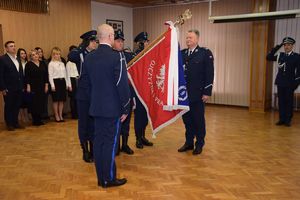 Poczet sztandarowy stoi na środku auli , z jednej strony sztandaru stoi mł. insp. Grzegorz Kurek, z drugiej strony podinsp. Tomasz Lubiński.