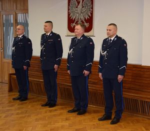 A auli wieluńskiej jednostki Policji stoi I Zastępca Komendanta Wojewódzkiego Policji w Łodzi, po jego prawej stronie stoi podinspektor Tomasz Lubiński, z lewej strony młodszy inspektor Grzegorz Kurek  oraz I Zastępca Komendanta Powiatowego Policji w Wieluniu.
