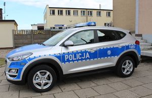 Radiowóz stoi na parkingu przed wieluńska jednostką Policji.