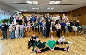 Policjantka prowadzi rozmowę z dziećmi w sali Wieluńskiego Spółdzielczego Domu Kultury.