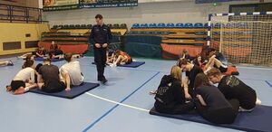 Uczniowie w grupach siedzą na materacach i rozwiązują test.