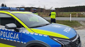 Policjant mierzy prędkość pojazdów miernikiem prędkości.