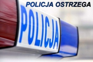 Światła błyskowe na dachu radiowozu i napis policja ostrzega.