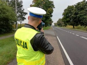Policjant mierzy prędkość na drodze.