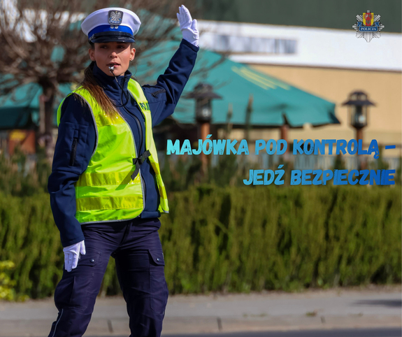 Policjntka kieruje ruchem i napis Majówka pod kontrolą jedź bezpiecznie.
