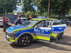 Młodzież ogląda radiowóz.