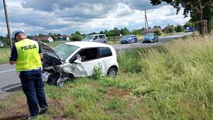 Policjant umundurowany obok uszkodzonego pojazdu