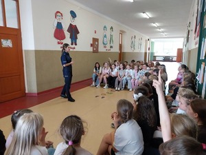 Policjantka prowadzi pogadankę z dziećmi w szkole.